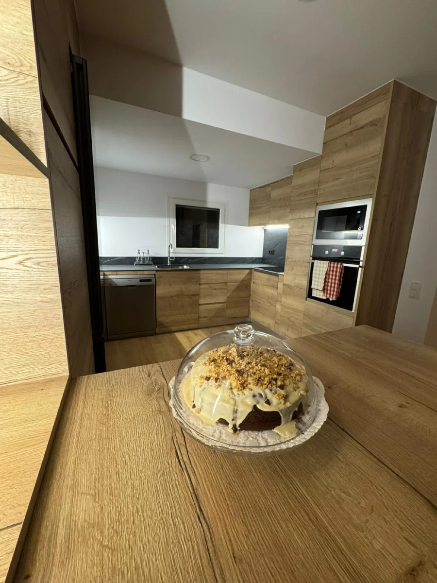 Cuina en fusta natural amb detalls negres a Vic
