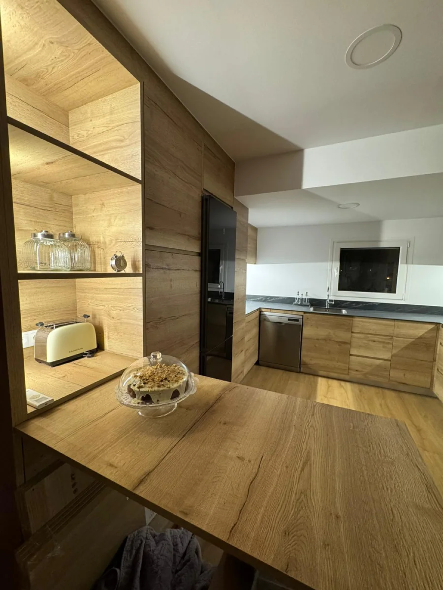 Cuina en fusta natural amb detalls negres a Vic